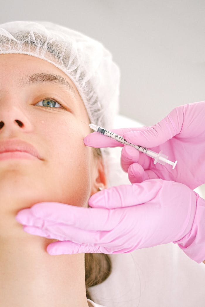 why-choose-us Close-up of a beautician administering facial injection treatment to a woman in a clinical setting.